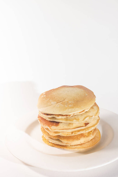 pancakes are stacked on a white plate. On a white background - Fotó, kép