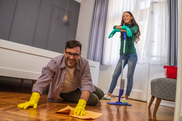 若い幸せなカップルがアパートを掃除してる. - 写真・画像