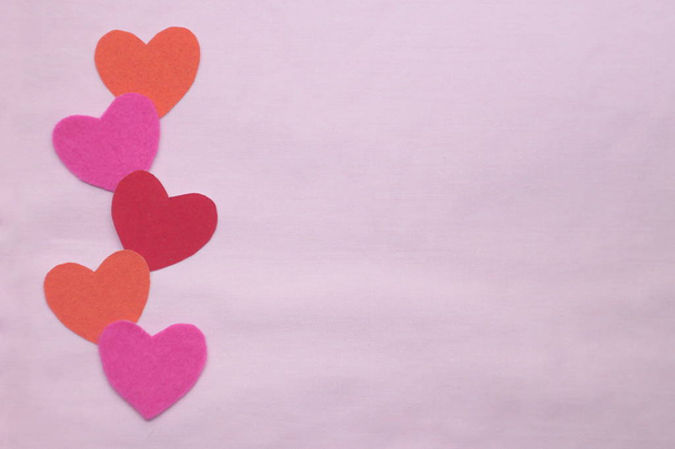 Colored hearts lie on a pink background. Copy space. - Φωτογραφία, εικόνα