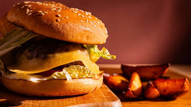Las hamburguesas sobre la tabla de madera con las patatas. Sabrosa foto comida rápida. Lugar para el texto
. - Foto, Imagen