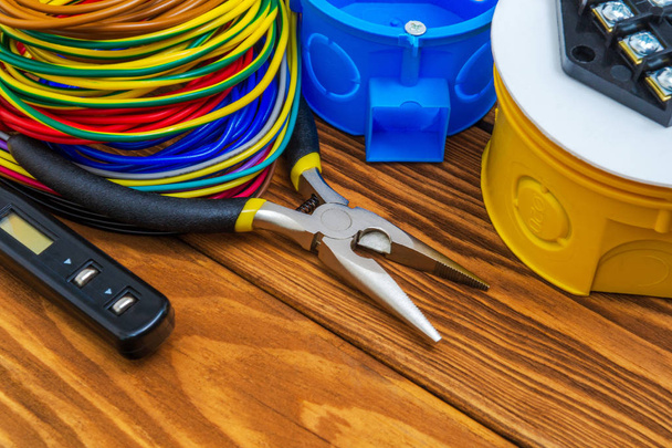 Cajas de conexiones eléctricas con cables de alambre y herramientas utilizadas en el proceso de instalación eléctrica
 - Foto, Imagen