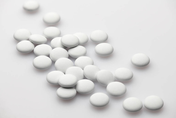 Group of white pills on white background - healthcare and medicament concept. Pharmaceutical industry. Pharmacy. - 写真・画像