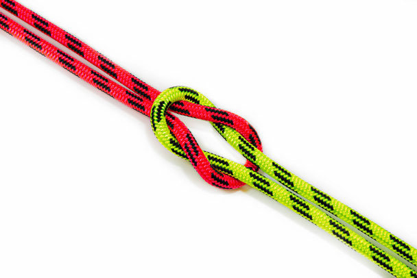 Reef, Hercules, square, double or brother hood Binding knot binding two colored red and green ropes. nautical loop used to secure rope or fishing line around an object. Isolated on white background - Photo, Image