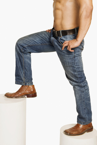 Man in jeans climbing up steps - Фото, зображення