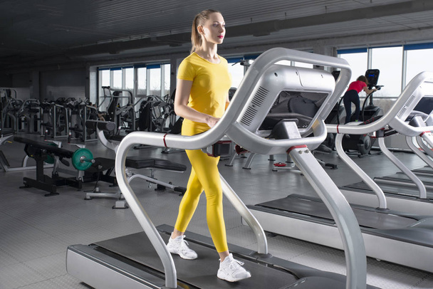 Young woman walking on treadmill in gym - Photo, Image
