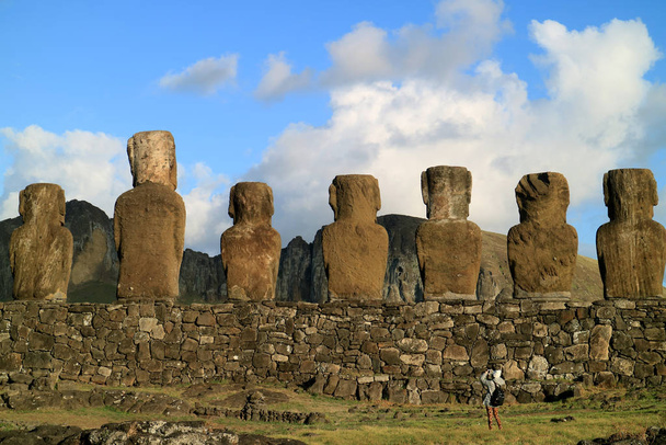 Female traveler photographing the back of gigantic Moai statues at Ahu Tongariki ceremonial platform on Easter Island, Chile - 写真・画像