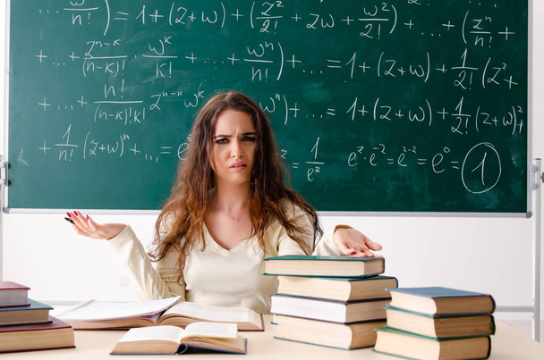 Молодая учительница математики перед доской - Фото, изображение