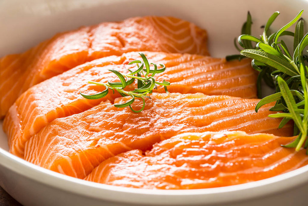 Raw salmon fillets with herbs in a baking dish - Foto, Imagen