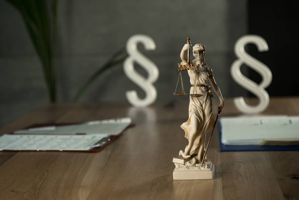 Blind Goddes Themis holding scales on wooden table background with blurred documents - Fotografie, Obrázek