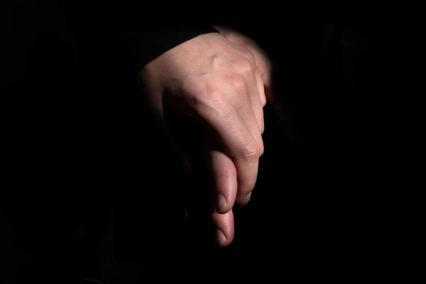 male and female hands in a gentle touch on a black background - Фото, зображення