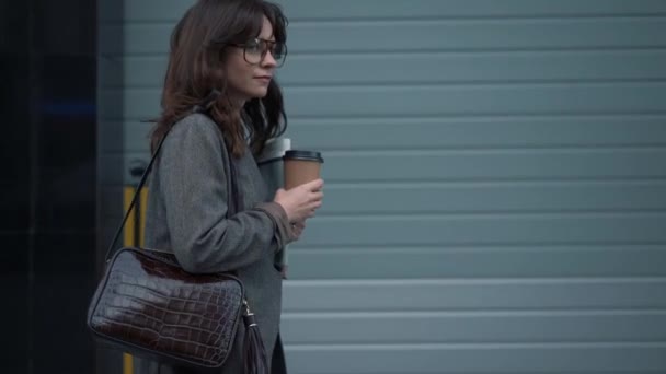 Slow motion profile of business woman in eyeglasses with a cup of coffee - Filmati, video