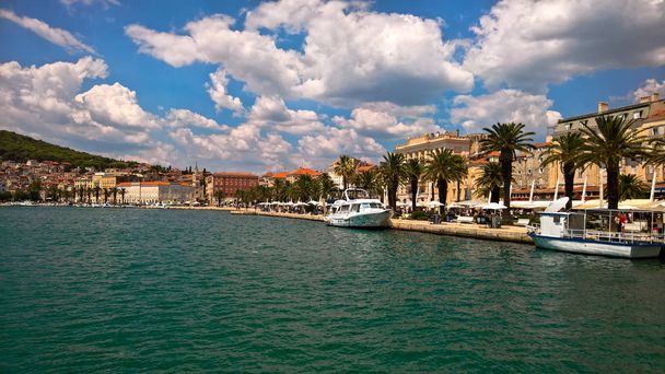Vista sul mare nel centro storico della città di Spalato. Edifici romanici lungo il molo soleggiato con palme
. - Foto, immagini