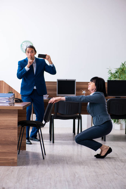 Two employees doing sport exercises in the office - Photo, Image