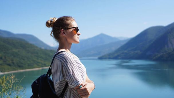 Smiling woman against mountain landscape and lake - Foto, imagen