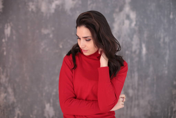 portrait of a beautiful girl with dark hair in a red turtleneck in a good positive mood - Photo, Image