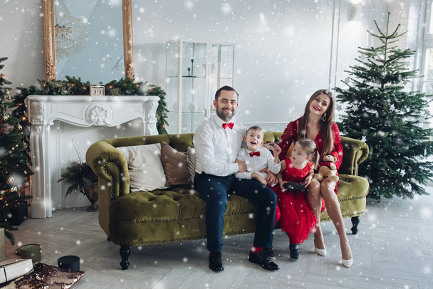 Bonne famille festive souriant posant à l'intérieur de vacances de luxe Décembre à fond d'arbre de Noël
 - Photo, image