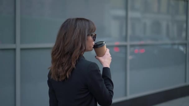 Slow motion profile of business woman in sunglasses with a cup of coffee - Πλάνα, βίντεο