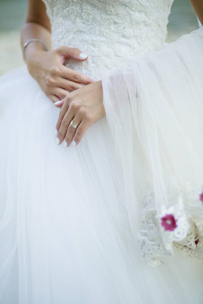 Bride dressed in wedding dress and her white hands  - Фото, зображення