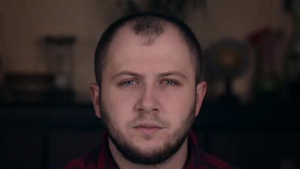 A young guy of European appearance in a plaid shirt closeup looks in surprise. Emotion concept - Video