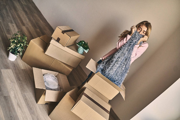 Boldog lány kicsomagolás kartondoboz után költözött az új lakás - Fotó, kép