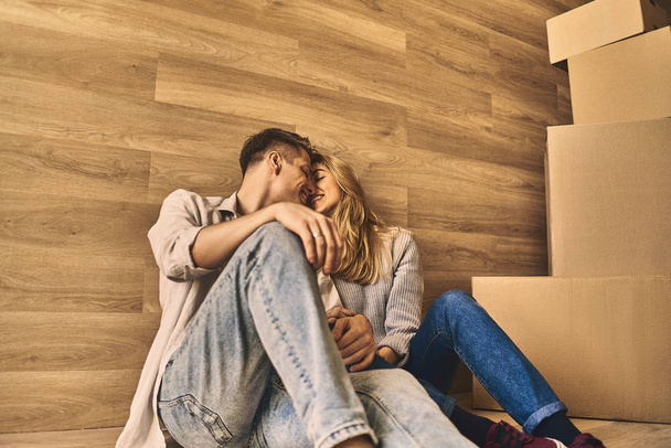 Young couple sitting on the floor in love in after moving into n - Photo, image