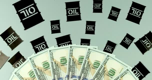 Papieranwendung Ölfässer auf einem Hintergrund von Geld-Dollar-Banknoten. - Filmmaterial, Video