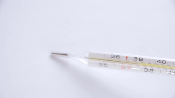 Selective focus on Thermometer on white background 4k video. High temperature indicating fever. Thermometer isolated. - Footage, Video