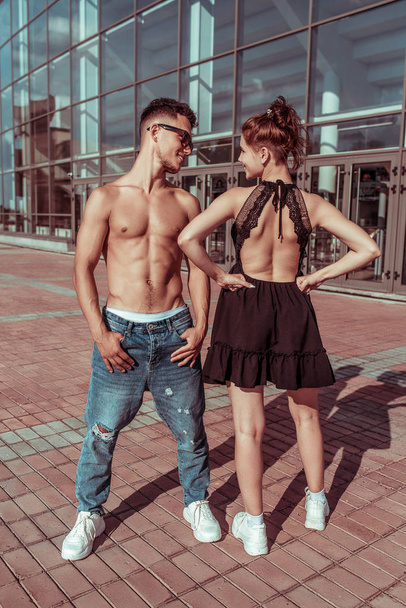 cheerful couple man and girl, laughing, dancers trained and tanned torso, dance sport, summer in city, hip hop, dance style, youth lifestyle. Street urban fitness motivation. - Valokuva, kuva