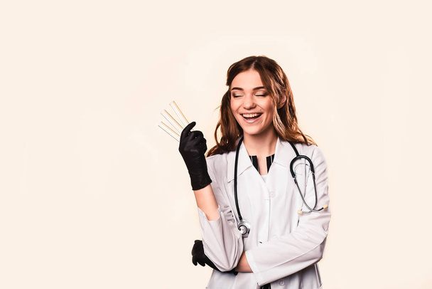 happy beautiful female doctor in medical coat standing with crossed arms isolated on white - Valokuva, kuva