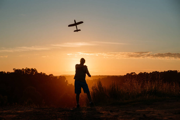 homme avec avion au coucher du soleil
 - Photo, image