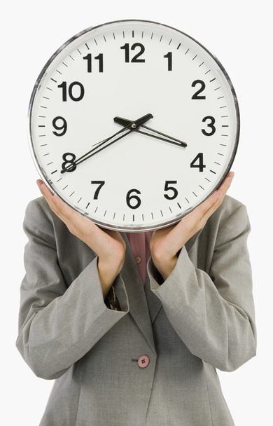 Businesswoman hiding her face with a clock - Photo, image