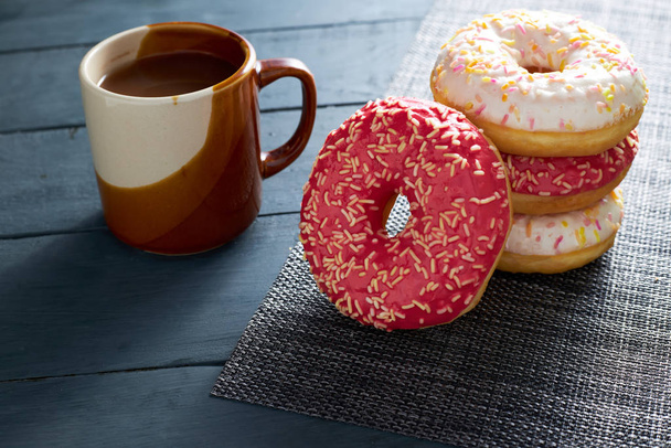 Colorful donuts and chocolate cup on dark wooden background. Morning breakfast. - Φωτογραφία, εικόνα