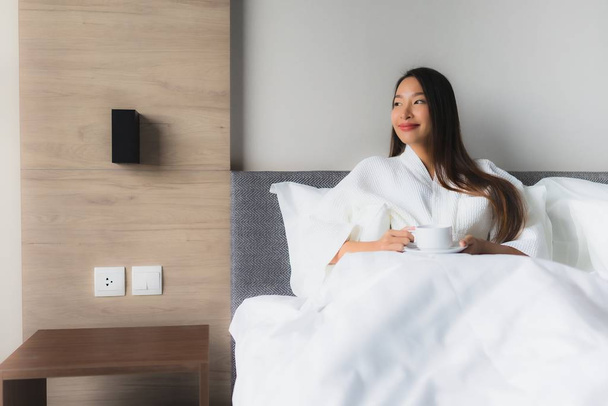 Porträt schöne junge asiatische Frauen mit Kaffeetasse auf dem Bett - Foto, Bild