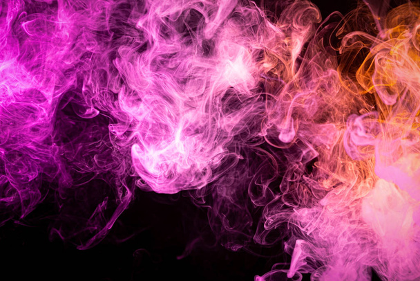Ροζ και πορτοκαλί σύννεφο καπνού από μαύρο απομονωμένο φόντο. Ιστορικό από τον καπνό του ατμού - Φωτογραφία, εικόνα