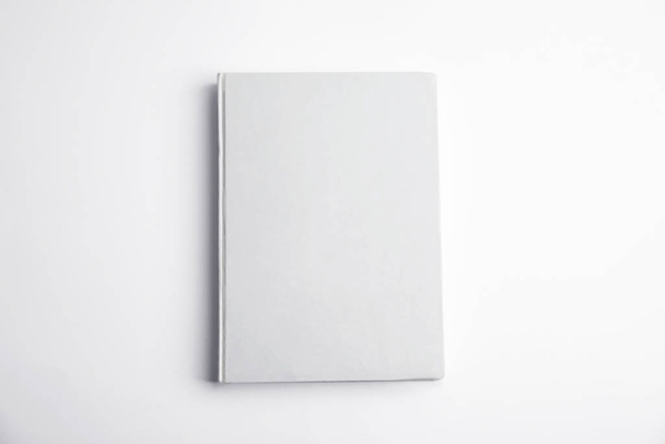 Book with blank cover on white background, top view - Foto, afbeelding