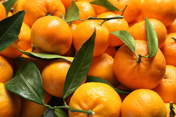 Fresh ripe tangerines with leaves as background, closeup. Citrus fruit - Fotoğraf, Görsel