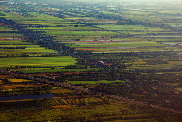 Aerial view of surrounding residential area and green rice fields in countryside land, beside Chao Phraya river. - Zdjęcie, obraz