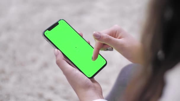 Woman using smartphone watching green screen on mobile phone.  Digital internet modern screen smart phone. Green Mock-up Screen Smartphone. - 映像、動画
