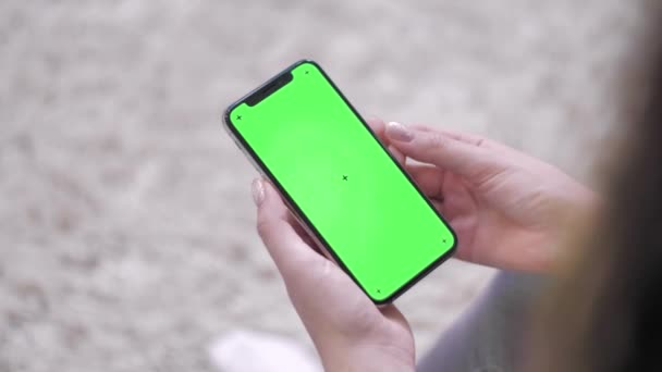 Mujer usando smartphone viendo pantalla verde en el teléfono móvil. Teléfono inteligente de pantalla moderna de Internet digital. Smartphone de pantalla falsa verde
. - Metraje, vídeo