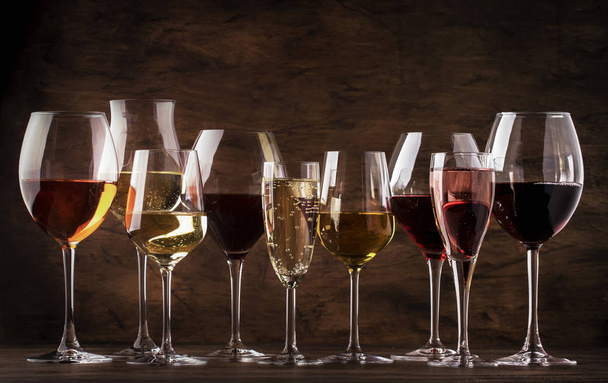 Borkóstoló koncepció, csendes és pezsgő. Piros, fehér bor, rózsa és pezsgő borospohárban vintage fa asztal háttér - Fotó, kép