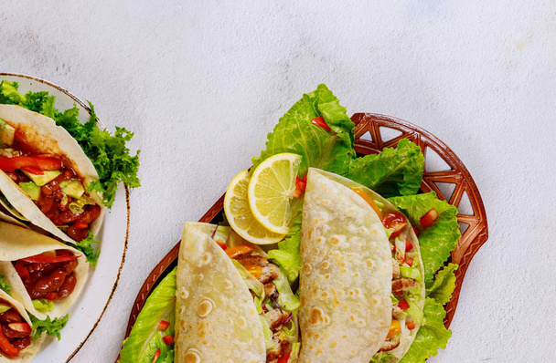 Mexikói ételliszt tortilla salátával, hússal és sajttal töltve. - Fotó, kép