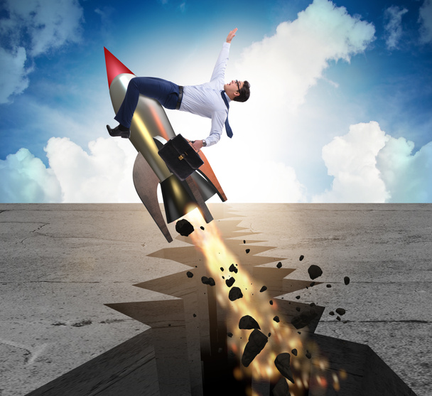 Businessman flying on rocket from rock gap - Photo, Image
