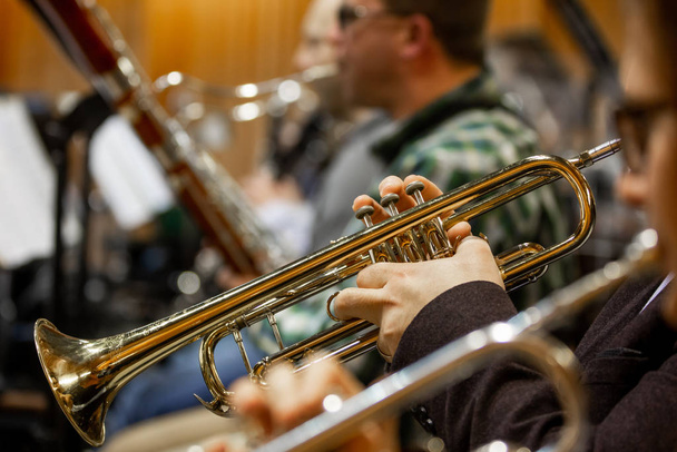 Деталь оркестра, филармонисты, играющие на трубах во время огромного филармонического концерта
 - Фото, изображение