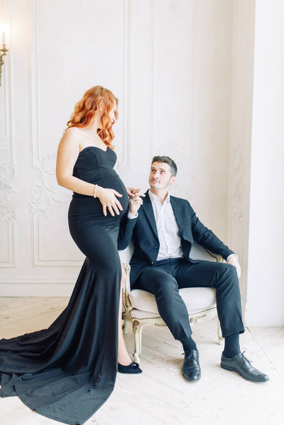  Family expecting a baby. Beautiful stylish couple in the Studio in evening images. - Fotó, kép