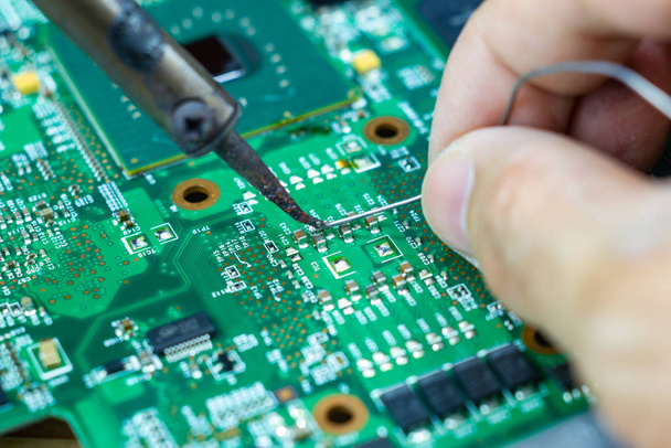 Technicians are using a soldering iron for repairing electronic  - Photo, Image