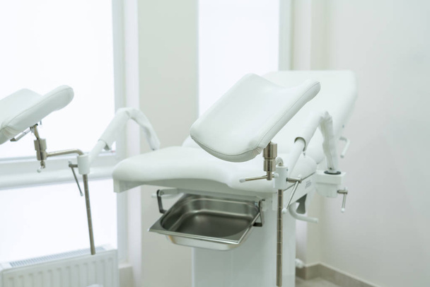 Пустой белый гинекологический кабинет в современном медицинском центре
 - Фото, изображение