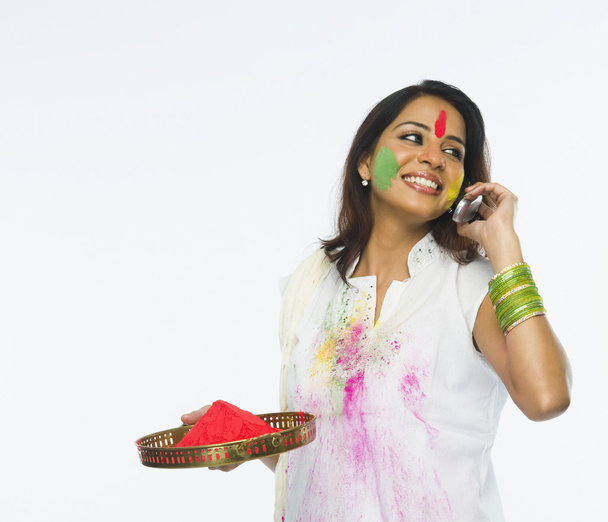 Woman holding Holi colors - 写真・画像