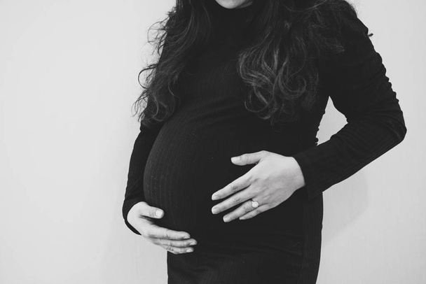 Pregnant woman feeling the baby. Young pregnant woman holds her  - Foto, afbeelding