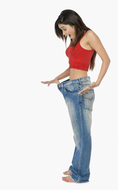 Woman pulling jeans - 写真・画像