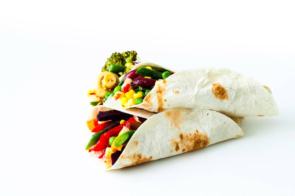 Tortilla mexicana con relleno de verduras y champiñones sobre fondo blanco. Concepto de alimentación saludable. Menú económico-amistoso.Primer plano
 - Foto, Imagen